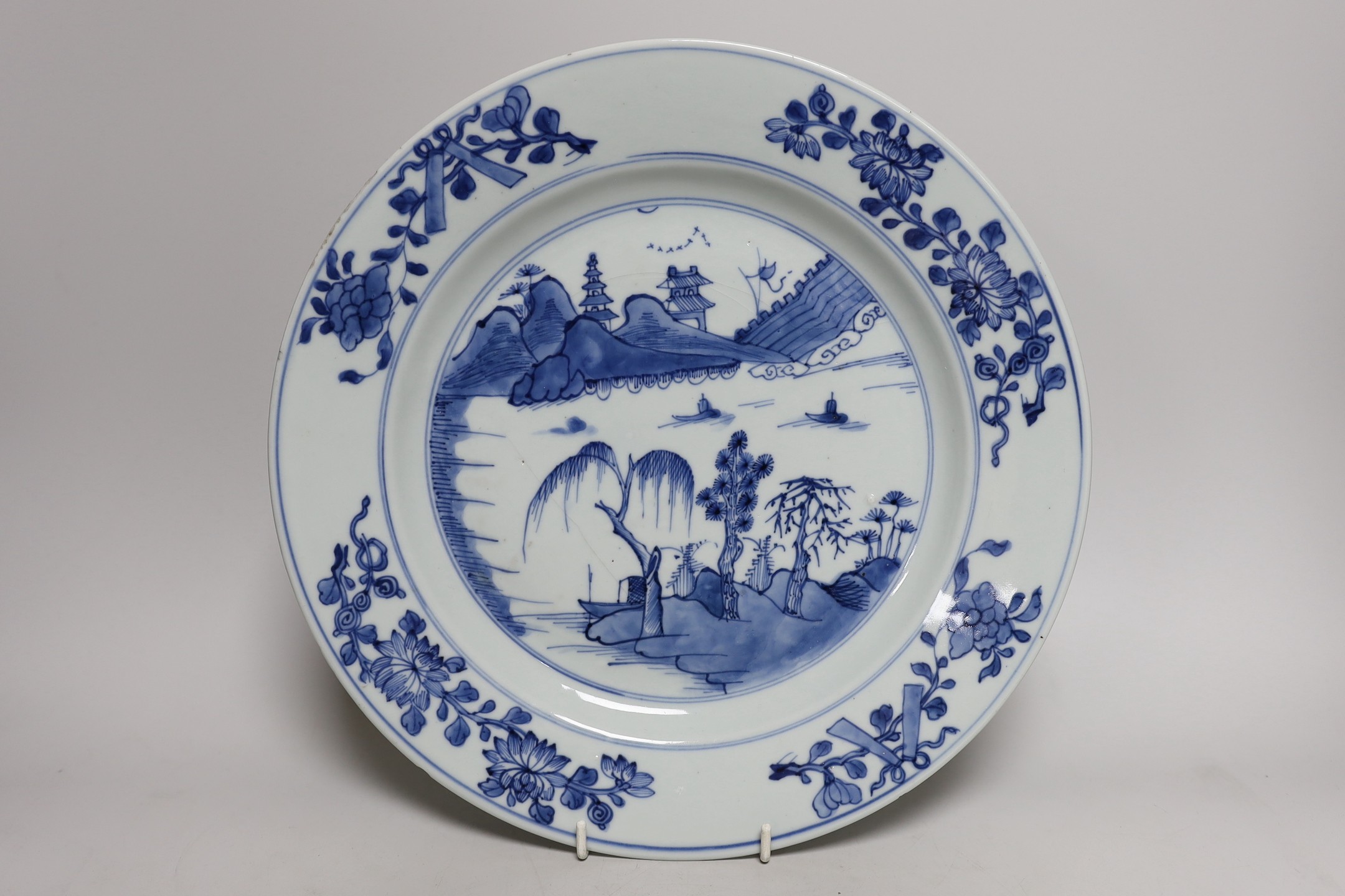 A Chinese blue and white landscape dish, Qianlong period 31cm diameter, together with a similar pair of tea bowls and saucers
